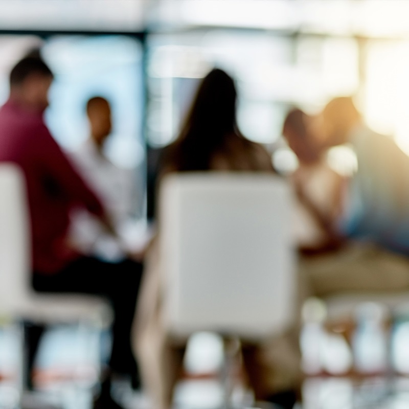 Blurry photo of business professionals sitting around board room table