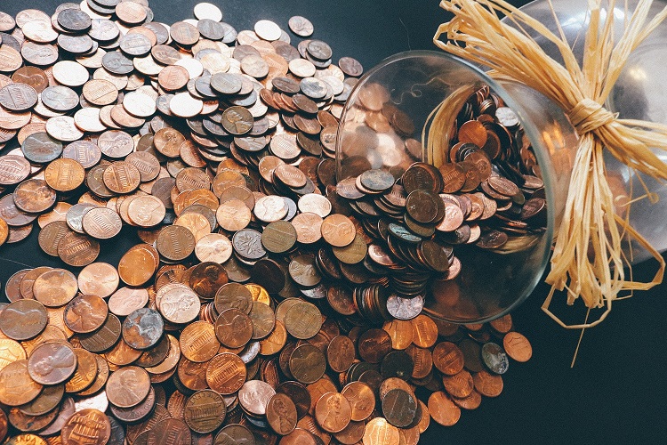 Pennies spilled from glass jar